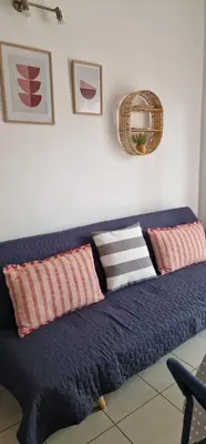 a blue couch with pillows on it in a room at Cosy little studio for family vacations ! in Rhodes Town