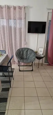 a living room with a couch and a tv and curtains at Cosy little studio for family vacations ! in Rhodes Town