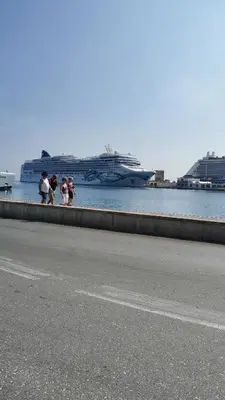 a group of people walking on a sidewalk near the water at Cosy little studio for family vacations ! in Rhodes Town