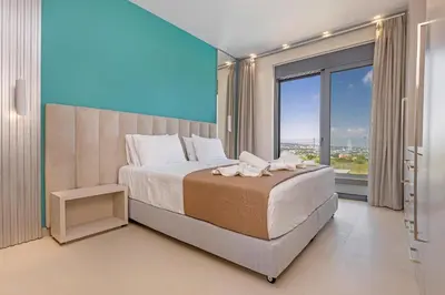 a bedroom with a large bed and a large window at Mont Fleury Resort in Koskinou