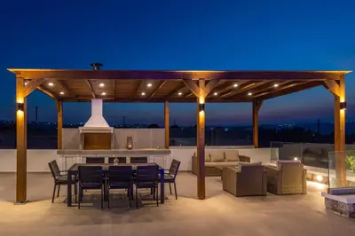a wooden pergola with a table and chairs on a patio at Mont Fleury Resort in Koskinou