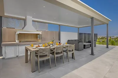 a kitchen and dining room with a table and chairs at Mont Fleury Resort in Koskinou