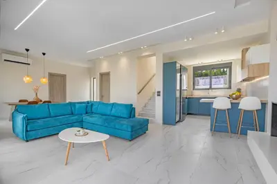 a living room with a blue couch and a table at Mont Fleury Resort in Koskinou