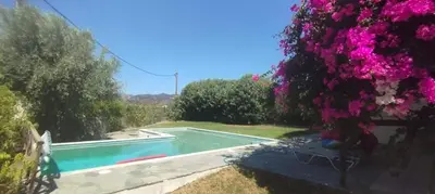 a house with a swimming pool and flowers at Villa Frangipani with large private pool, Rhodes in Lardos