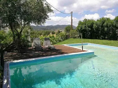 a swimming pool with two chairs and a tree at Villa Frangipani with large private pool, Rhodes in Lardos