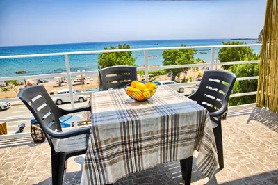 a table with a bowl of fruit on a balcony with the beach at Summer Paradise Stegna Rhodes in Archangelos