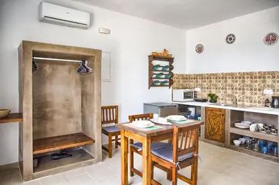 a kitchen with a table and chairs and a sink at Summer Paradise Stegna Rhodes in Archangelos