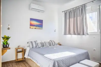 a white bedroom with a bed and a window at Summer Paradise Stegna Rhodes in Archangelos