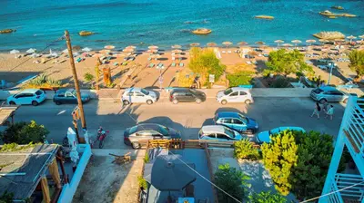 an aerial view of a beach with cars and umbrellas at Summer Paradise Stegna Rhodes in Archangelos