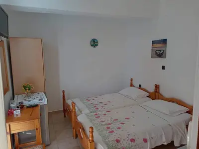 a bedroom with a bed and a table with a night stand at ZOGRAFOS 2 in Haraki