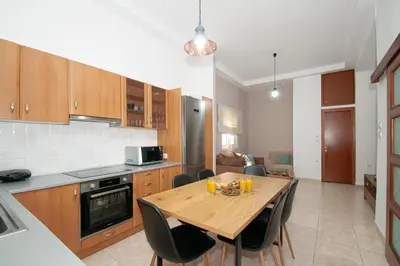 a kitchen with a wooden table and chairs in it at Vicinia Guest House in Rhodes Town