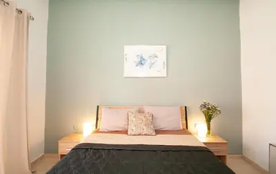 a small bedroom with a bed with two lamps at Vicinia Guest House in Rhodes Town