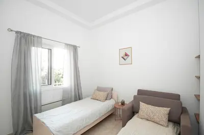 a bedroom with a bed and a couch and a window at Vicinia Guest House in Rhodes Town