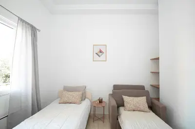 a small room with two beds and a window at Vicinia Guest House in Rhodes Town