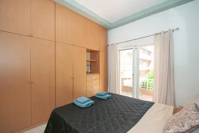 a bedroom with a bed with wooden cabinets and a window at Vicinia Guest House in Rhodes Town