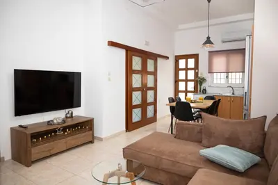 a living room with a couch and a flat screen tv at Vicinia Guest House in Rhodes Town