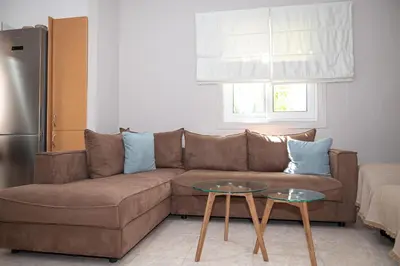 a living room with a brown couch and a table at Vicinia Guest House in Rhodes Town
