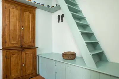 a room with a staircase and a wooden cabinet at Myrsini's House in Symi