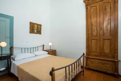 a bedroom with a bed and a wooden cabinet at Myrsini's House in Symi