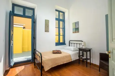 a small bedroom with a bed and a window at Myrsini's House in Symi