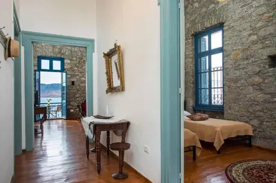 a living room with a table and a bed in a room at Myrsini's House in Symi