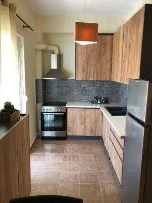 a kitchen with wooden cabinets and a stainless steel refrigerator at MATREL Home 2 in Rhodes Town