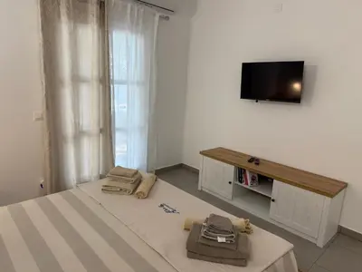 a bedroom with two beds and a flat screen tv at Deda Apartments in Livadia