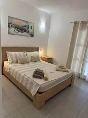 a bedroom with a large bed with two towels on it at Deda Apartments in Livadia
