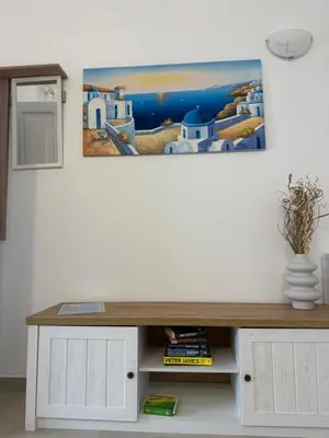 a living room with a table and a painting on the wall at Deda Apartments in Livadia
