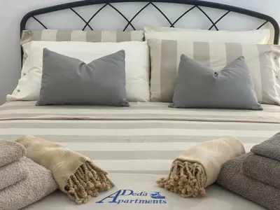 a white bed with pillows and blankets on it at Deda Apartments in Livadia