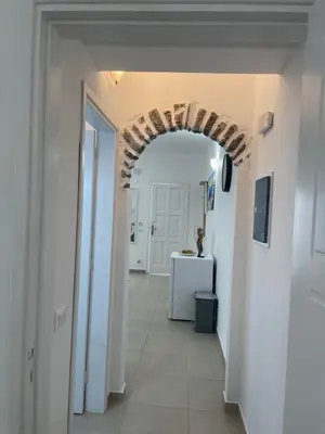 a hallway with an archway in a room with white walls at Deda Apartments in Livadia