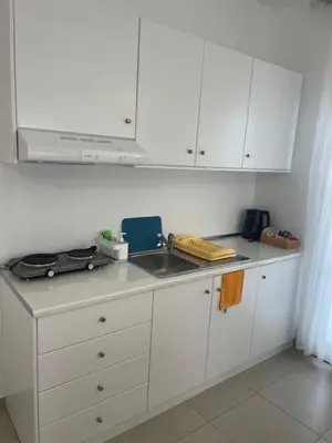 a kitchen with white cabinets and a sink at Deda Apartments in Livadia