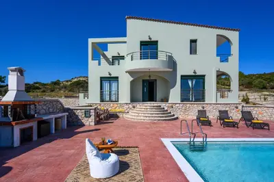 a house with a swimming pool in front of it at Alki Slow Living Villas in Afantou