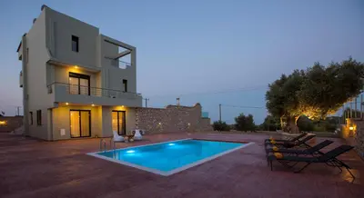 a villa with a swimming pool in front of a house at Alki Slow Living Villas in Afantou
