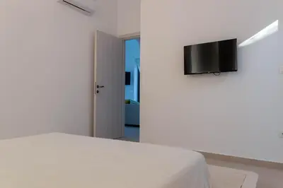 a bedroom with a bed and a flat screen tv on a wall at Villa Iliousa Princess in Psinthos