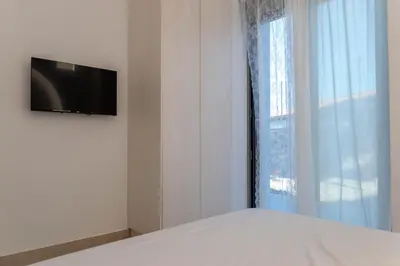 a bedroom with a bed with a television on a wall at Villa Iliousa Princess in Psinthos