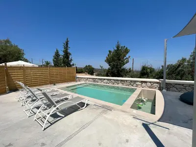a swimming pool with lounge chairs and a swimming pool at Villa Iliousa Princess in Psinthos