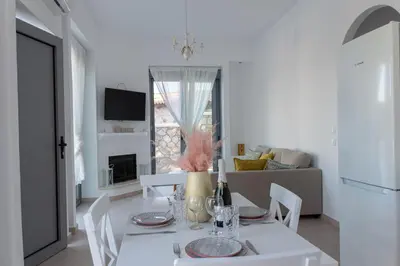 a white dining room with a table and chairs at Villa Iliousa Princess in Psinthos