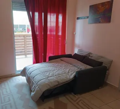 a bed in a room with a red curtain at Nikolettas Studios Traditional House in Paradeísion