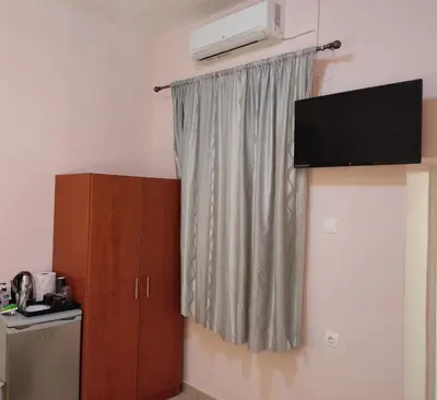 a room with a curtain and a television and a cabinet at Nikolettas Studios Traditional House in Paradeísion