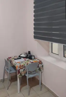 a table with two chairs and a table and a window at Nikolettas Studios Traditional House in Paradeísion