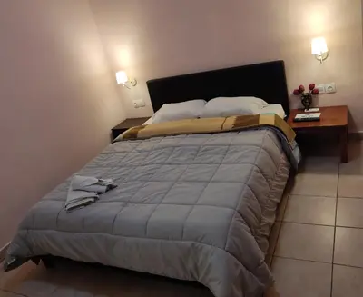 a bedroom with a large bed with a night stand at Nikolettas Studios Traditional House in Paradeísion