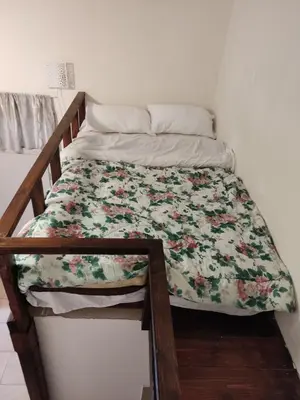 a bed with a floral comforter on it at Nikolettas Studios Traditional House in Paradeísion