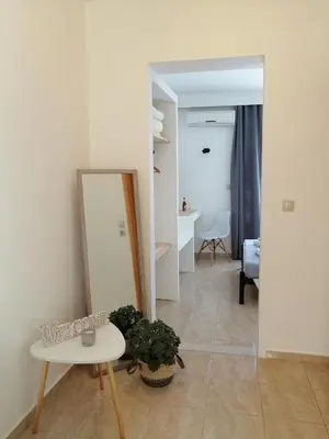 a living room with a mirror and a table at OASIS APARTMENTS in Livadia