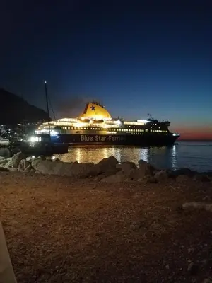 a large boat sitting on the water at night at OASIS APARTMENTS in Livadia