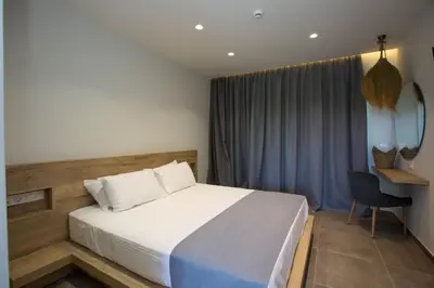 a bedroom with a bed and a chair in it at DeLight Luxury Rooms in Faliraki