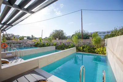 a swimming pool with a view of a building at DeLight Luxury Rooms in Faliraki