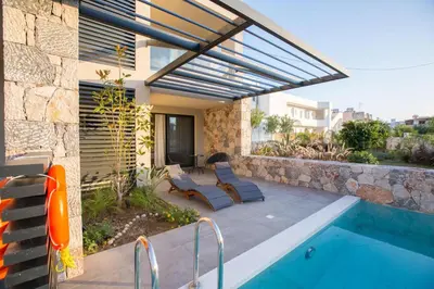 a house with a swimming pool next to a building at DeLight Luxury Rooms in Faliraki