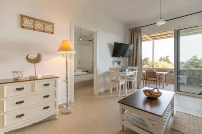a living room with a table and a dining room at Anastasia's Garden in Archangelos