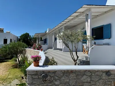 a white house with a stone wall at Anastasia's Garden in Archangelos